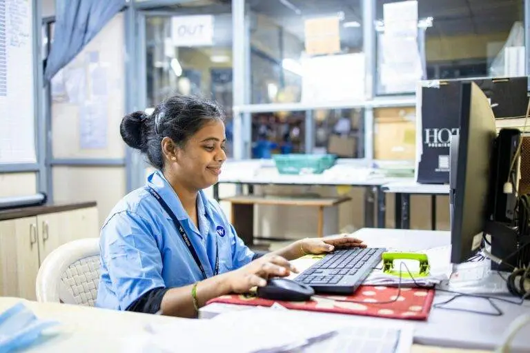 Woman works on a computer in an office.